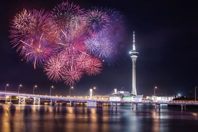 fireworks exploding over bridges and tower