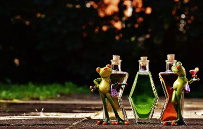 puppet frogs in front of bottles