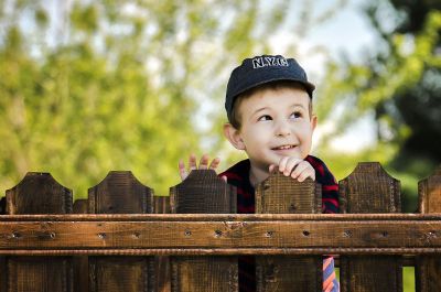 child smiling behind a fence