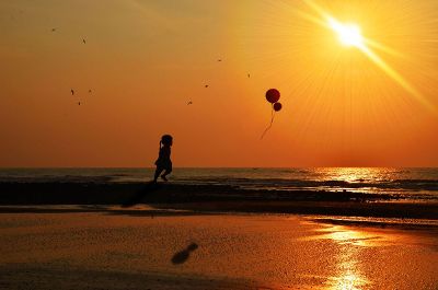 child catching balloons in the sea