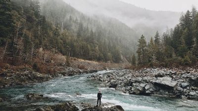 man staring at a mountain brook