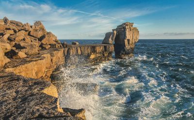 rough ocean waves break over rocky cliffs