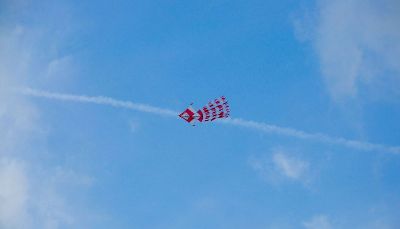 red and white kite flying in sky