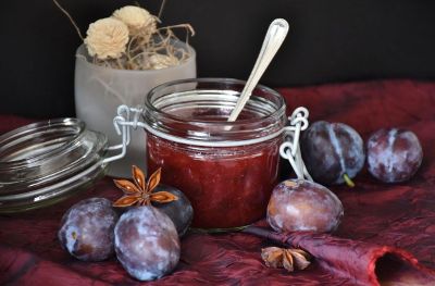 spoon in a bowl of jam with fruit on table