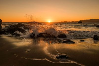 waves crash at sunset