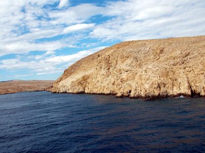 mountain of rock at the edge of water