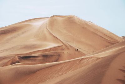 people walking on sand dune