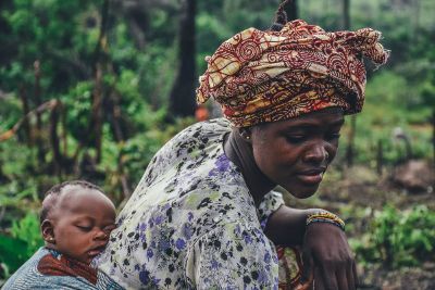 mother carrying baby while working