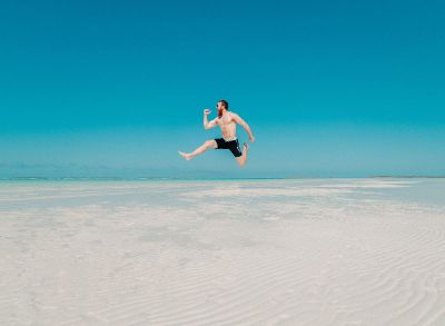 man jumping on beach