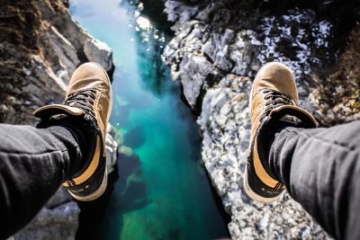 feet hanging over river