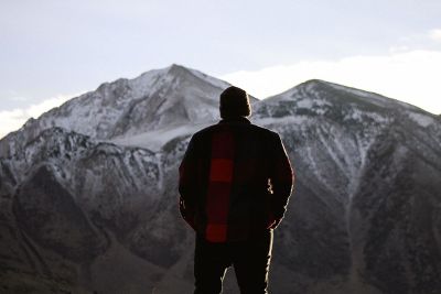 man standing in front of mountains