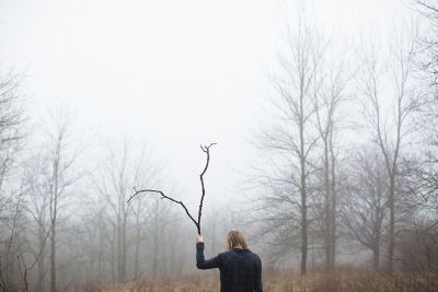person with branch in fog