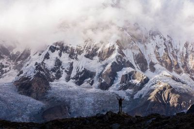 person looking up at snowy mountain