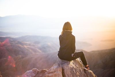 woman sitting on mountain top