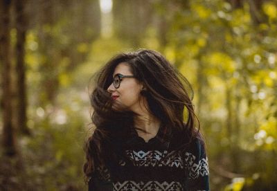 woman shaking hair in forest