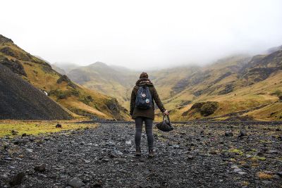 woman walking away toward mountain