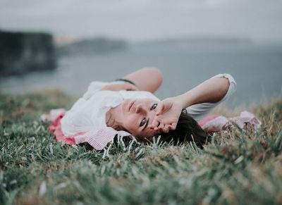 woman laying on grass looking behind