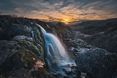 waterfall in a sunset landscape