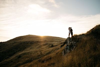 couples kiss on hillside