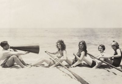 women practicing paddling on beach