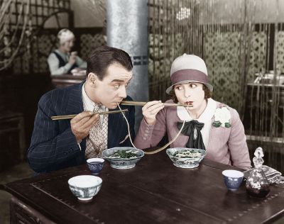 man and woman slurping noodle