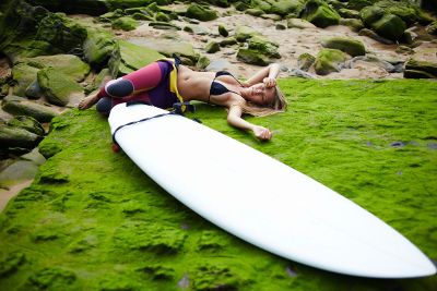 surfer lying alongside her board